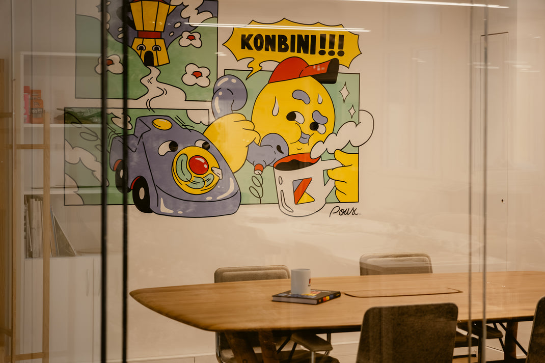 Colorful mural of cartoon characters on a wall with a table and chairs in the foreground.