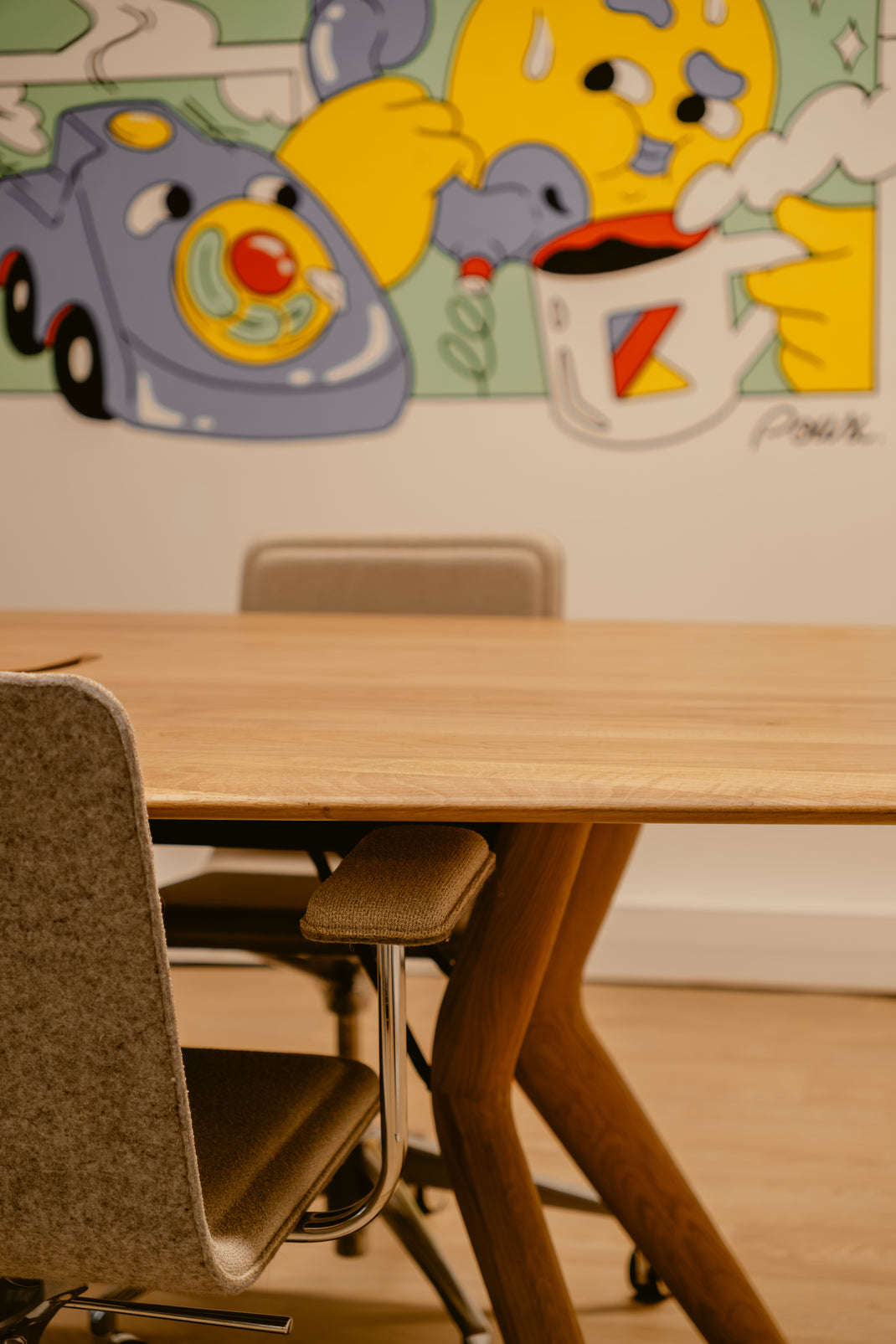 Wooden table with chairs in a room with colorful wall art