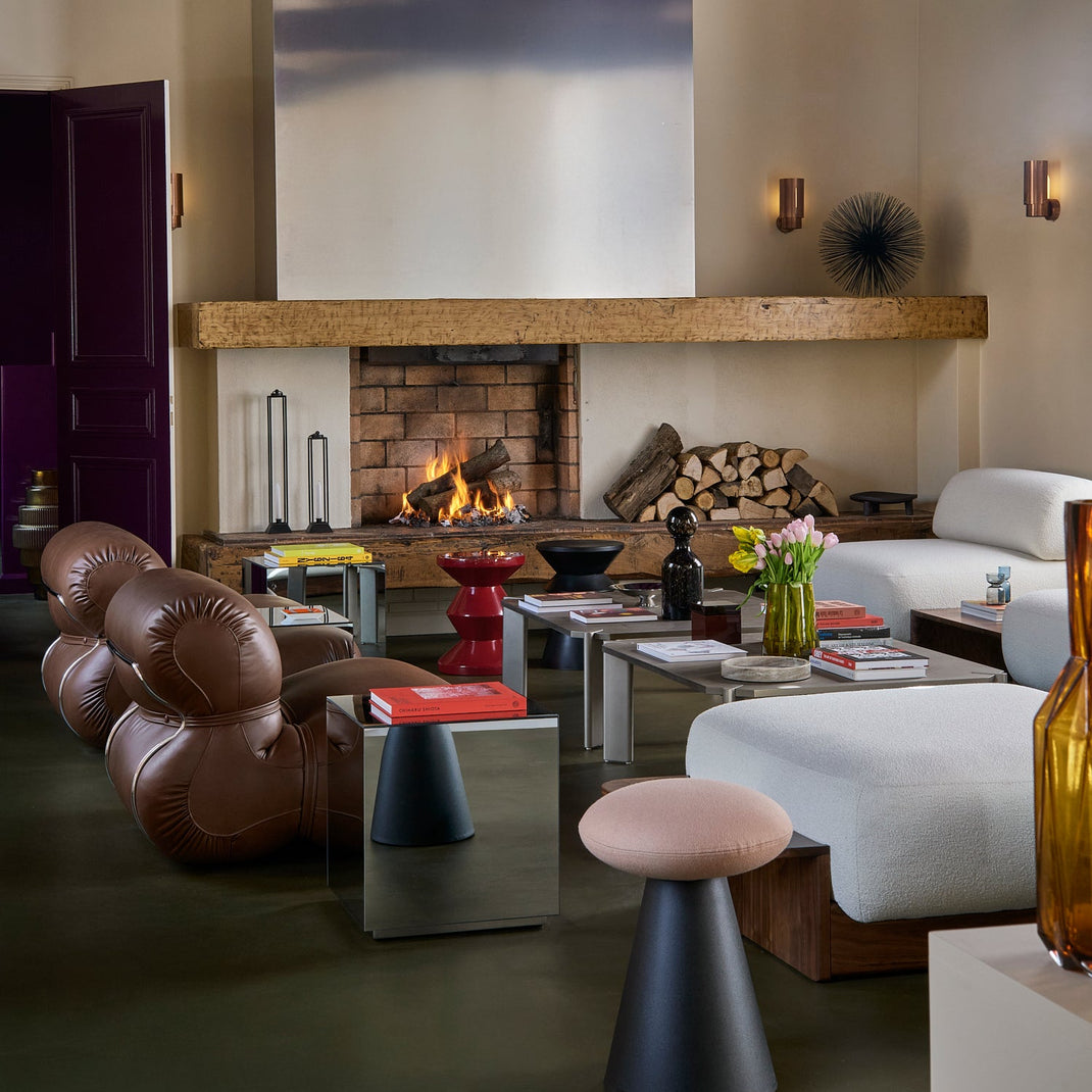 Modern living room with a fireplace, leather chairs, and decorative items.