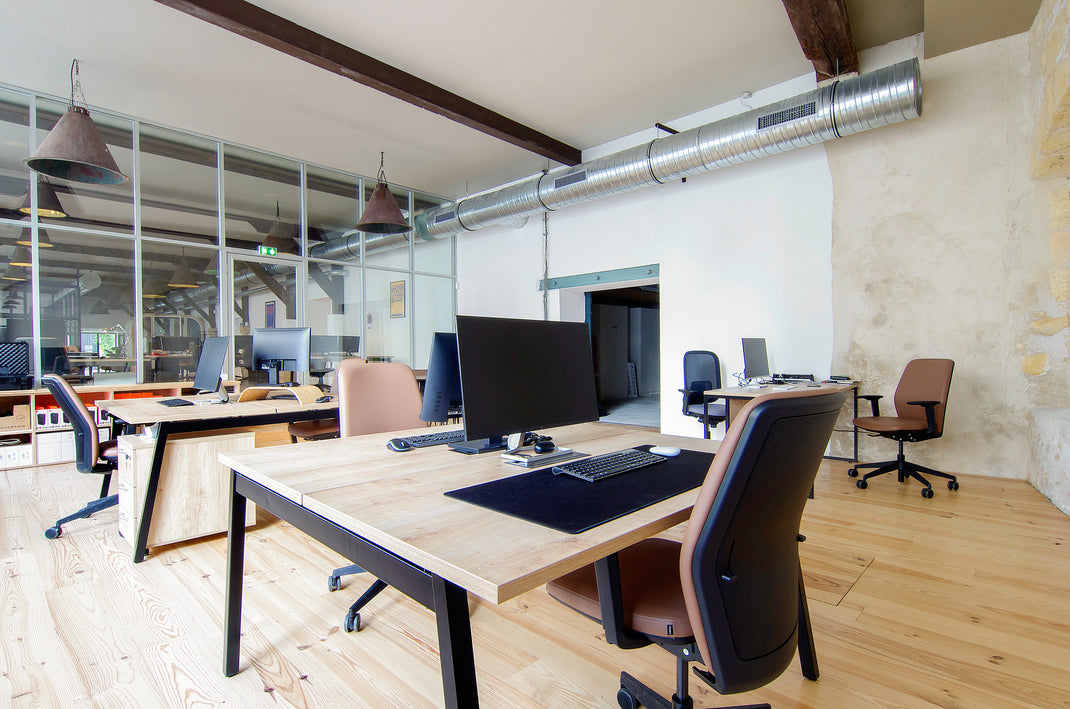 Modern office space with desks, chairs, and computer monitors.