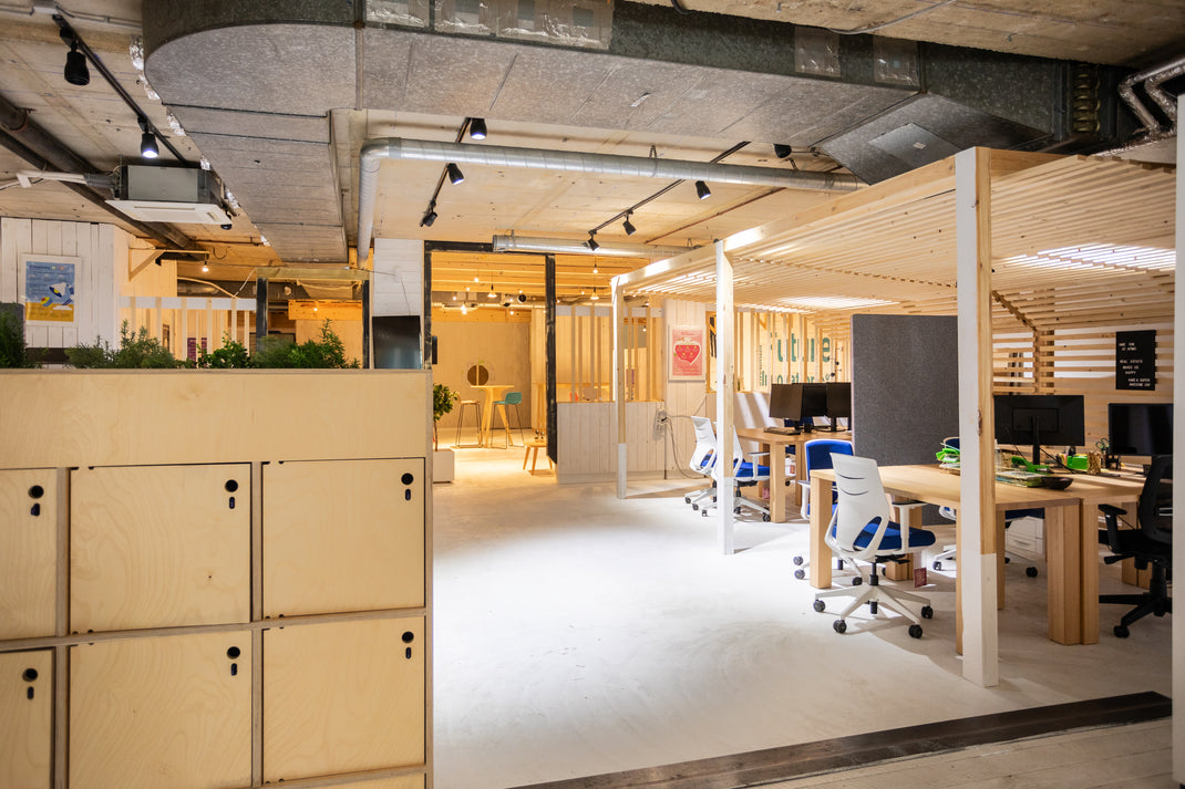 Modern office space with wooden lockers and open workstations.