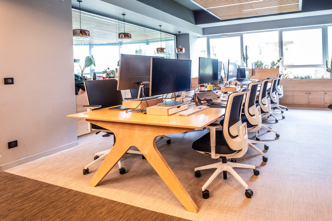 Modern office setup with desks, chairs, and computer monitors.