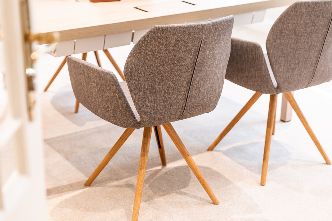 Two brown chairs with wooden legs in a room setting