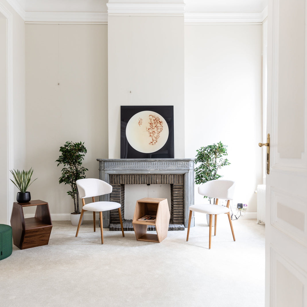 Welcome room in office with white chairs, a fireplace, and decorative items.