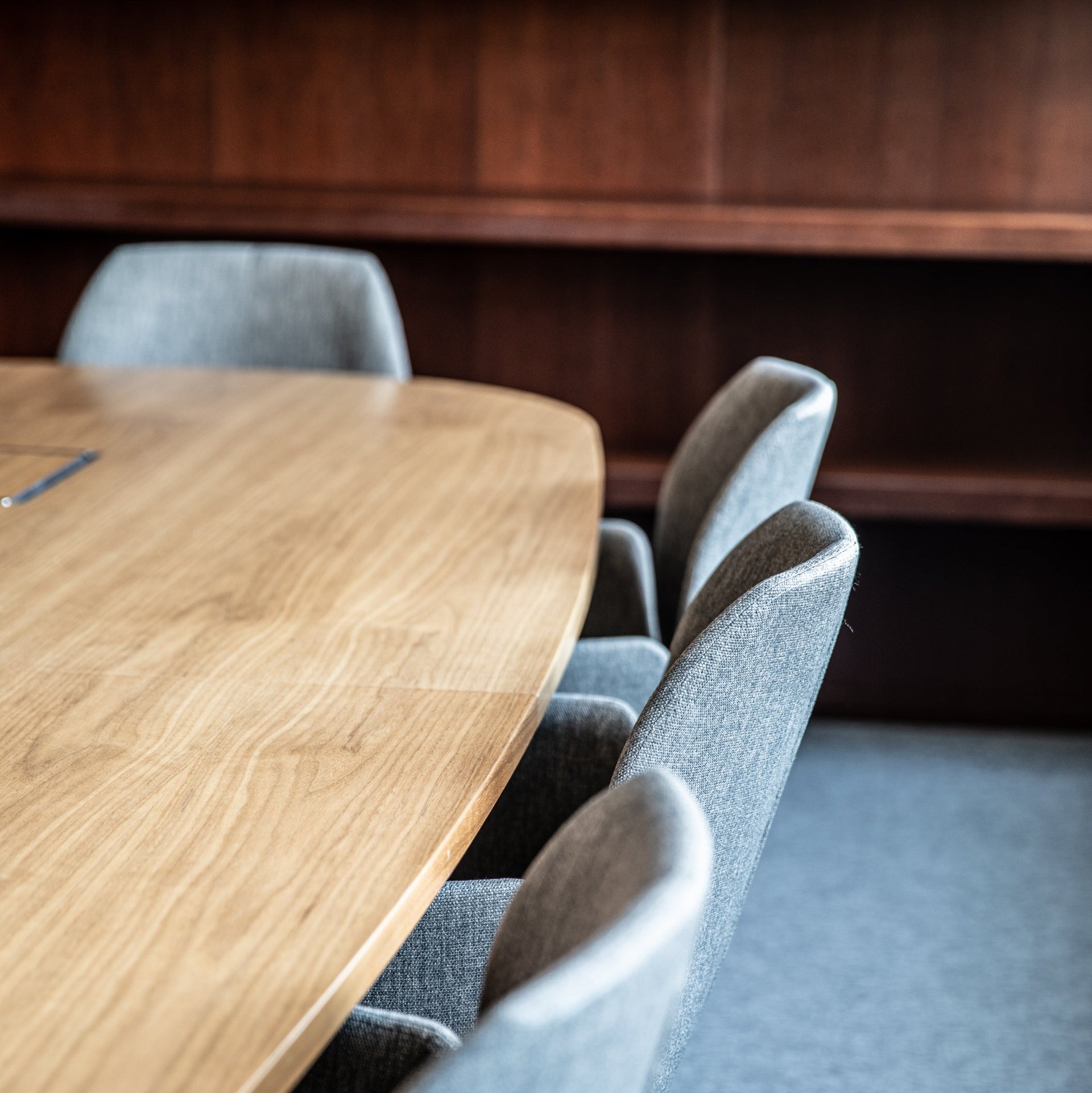 Wooden table with gray chairs in a room with wooden walls.