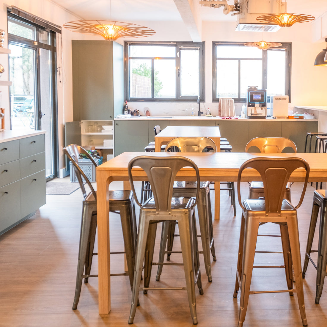 Modern kitchen with a long wooden dining table and metal chairs.