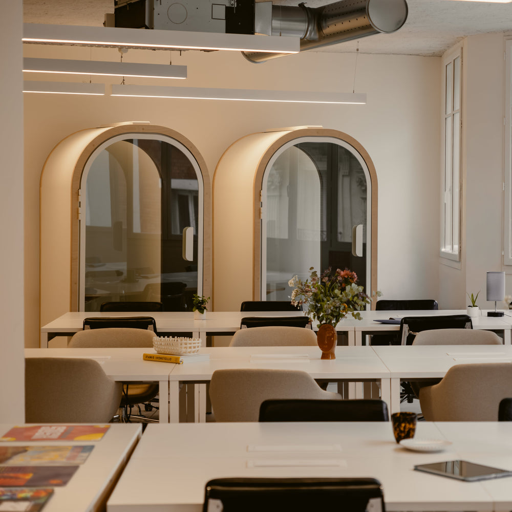 Modern office interior with tables, chairs, and decorative elements.