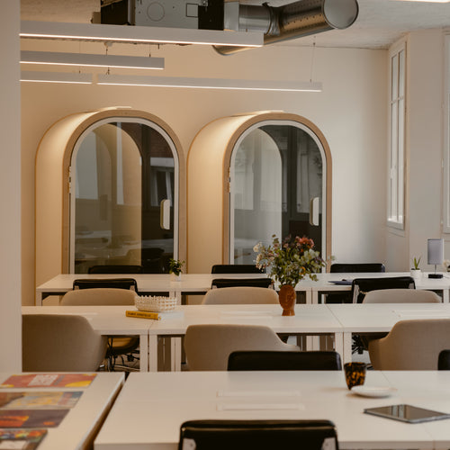 Modern office interior with tables, chairs, and decorative elements.