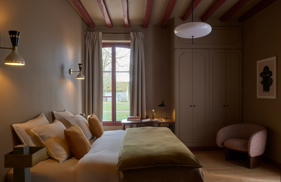 Cozy bedroom with a bed, lamp, and window view