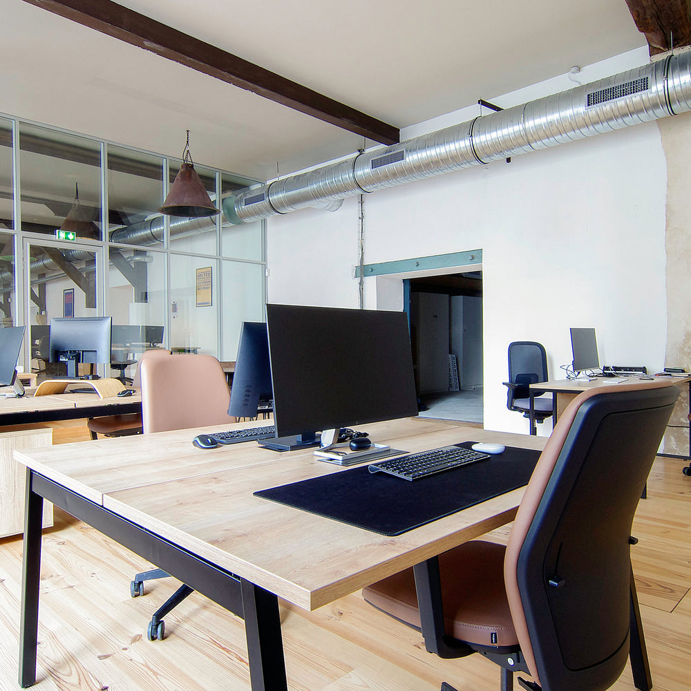 Modern office space with desks, chairs, and computer monitors.