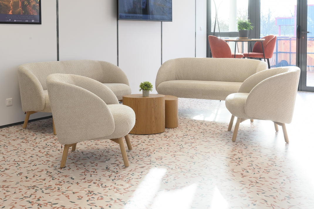 Modern beige sofa set in a room with large windows and a wooden coffee table.