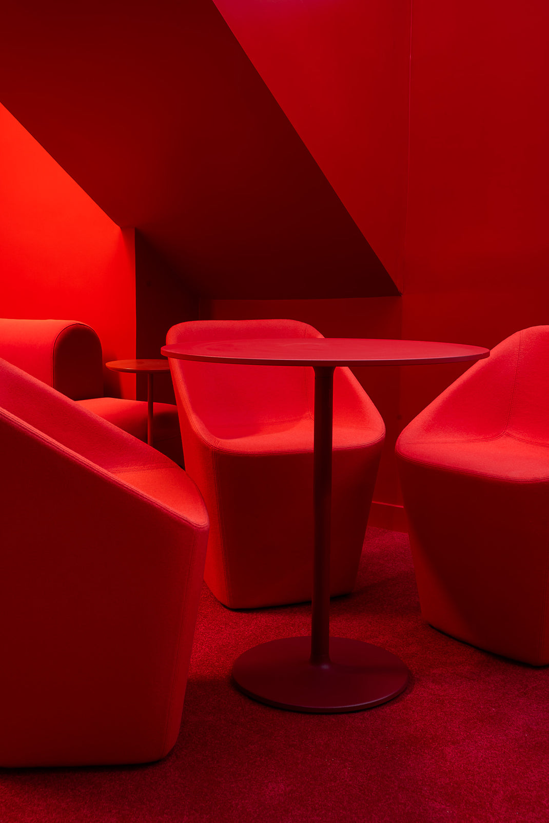 Red interior with chairs and a table against a red wall