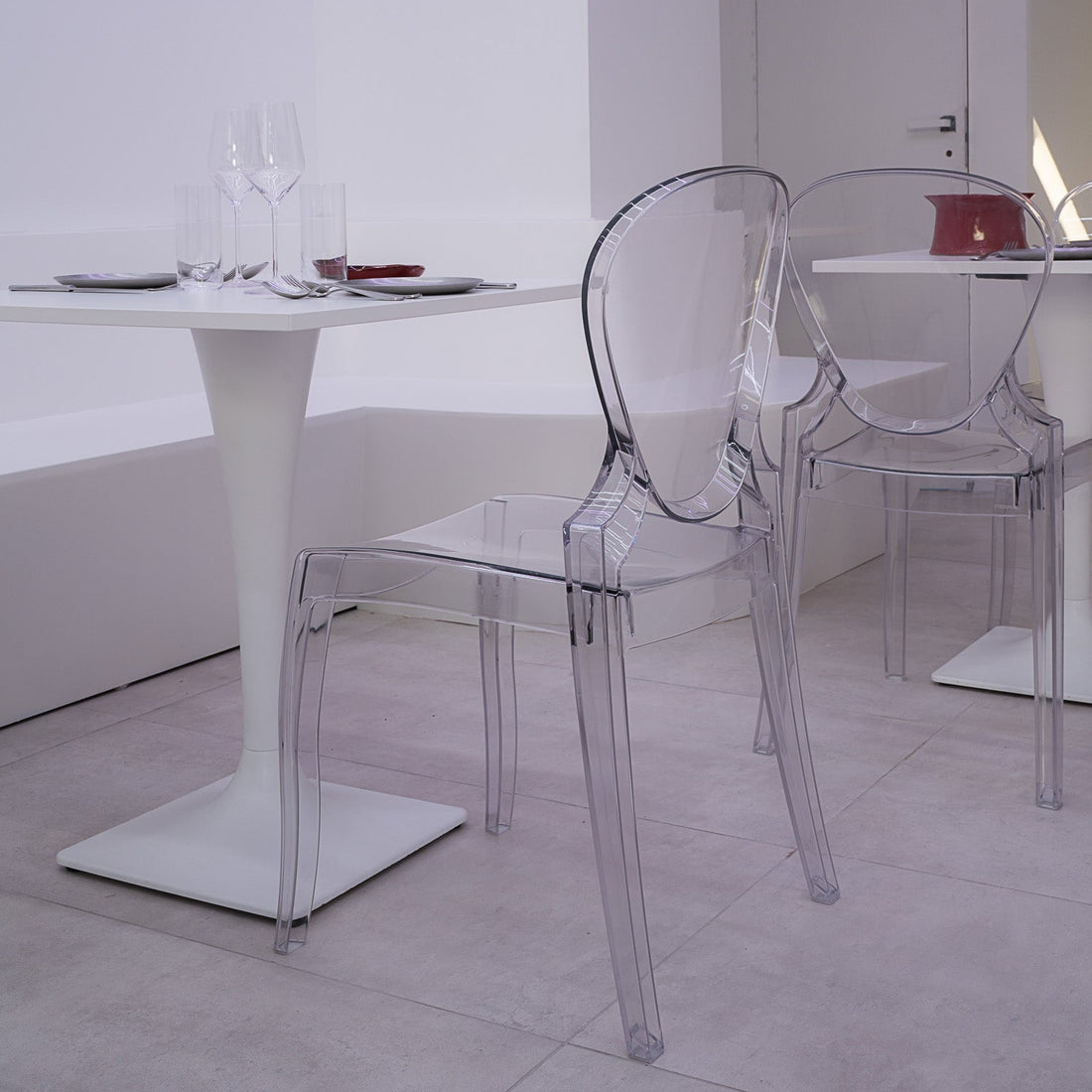 Modern dining area with clear chairs and a white table.