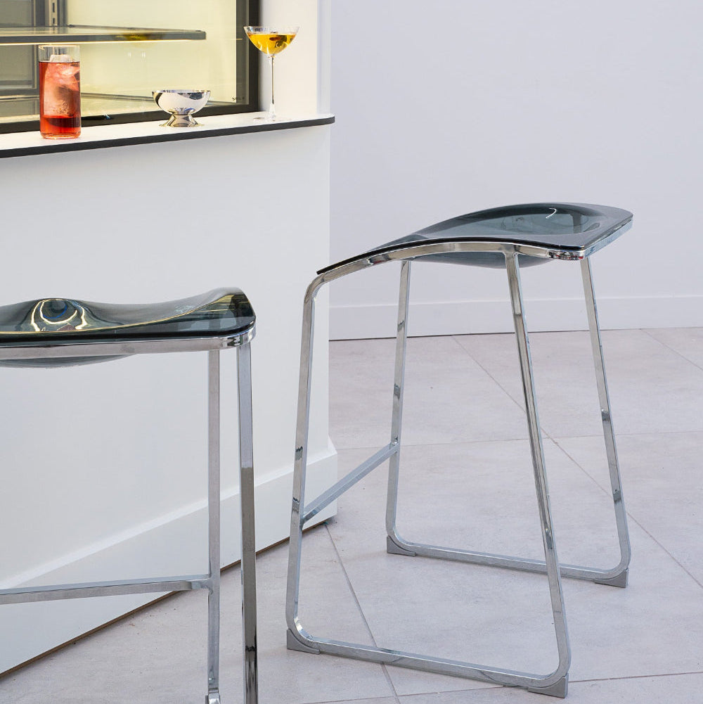 Modern bar stools with transparent seats in a minimalistic setting.