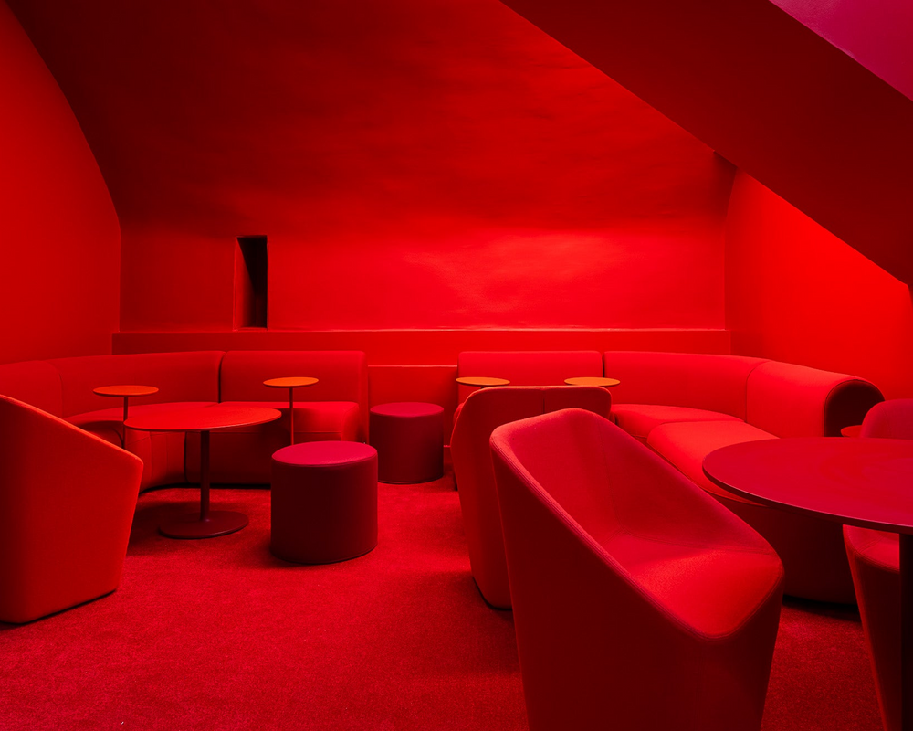 Red-themed interior with chairs and tables in a dimly lit room.