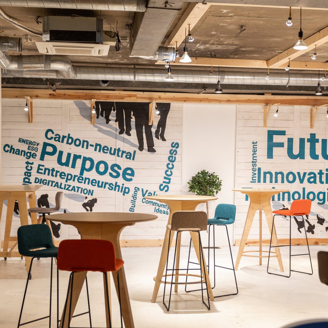 Modern communal open space to encourage informal gatherings and conversation. Motivational wall graphics and colorful chairs.
