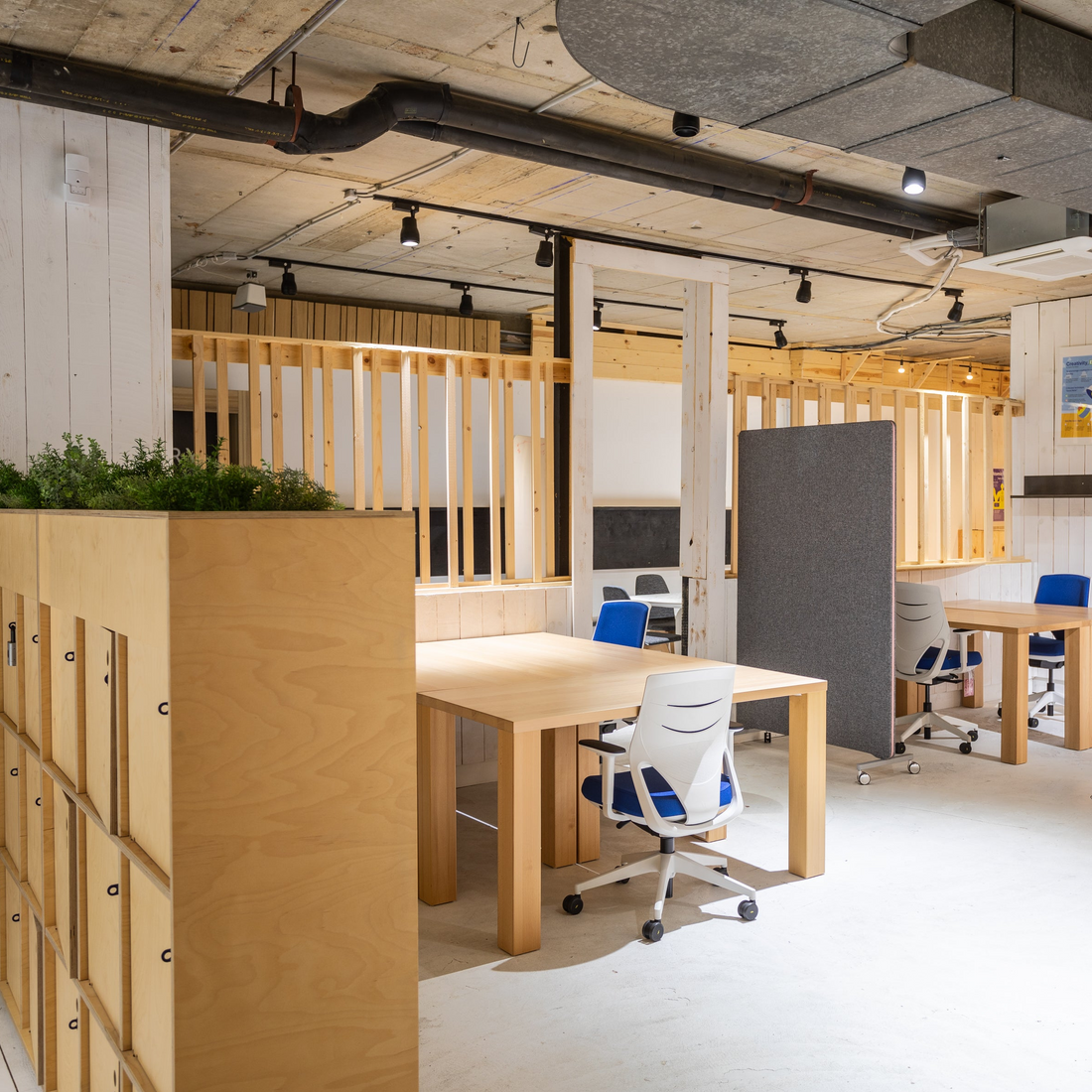 Modern office space with wooden partitions and desks.