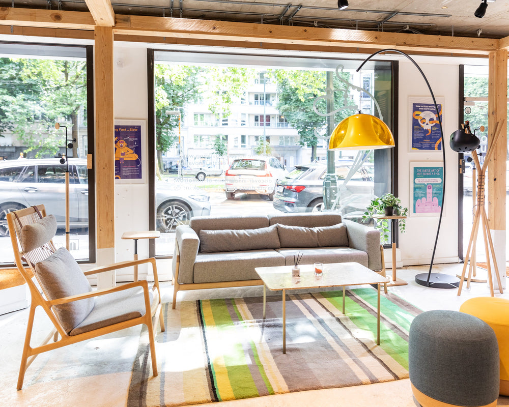 Modern interior design with a sofa, chairs, and a coffee table in a bright room with large windows.