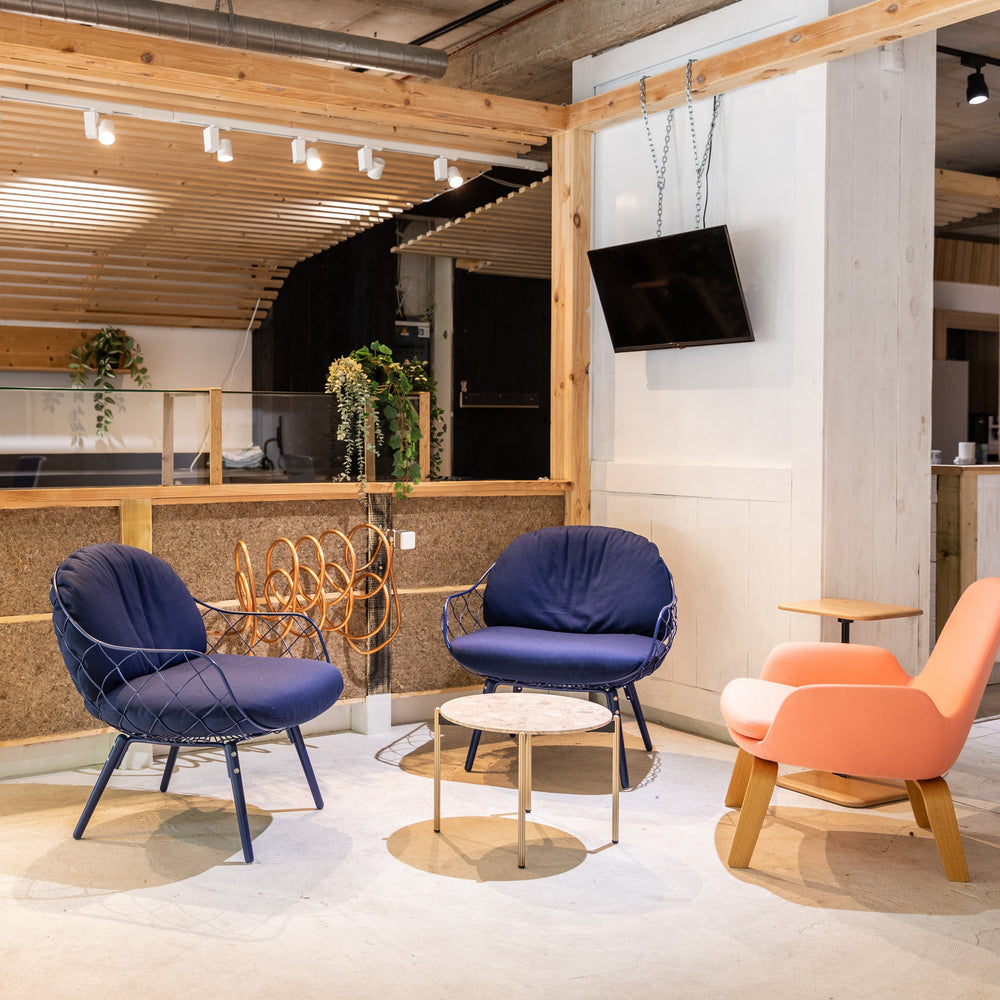 Modern interior with colourful chairs and a kitchen area for office teams. 