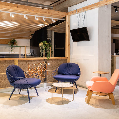 Modern interior with colourful chairs and a kitchen area for office teams. 