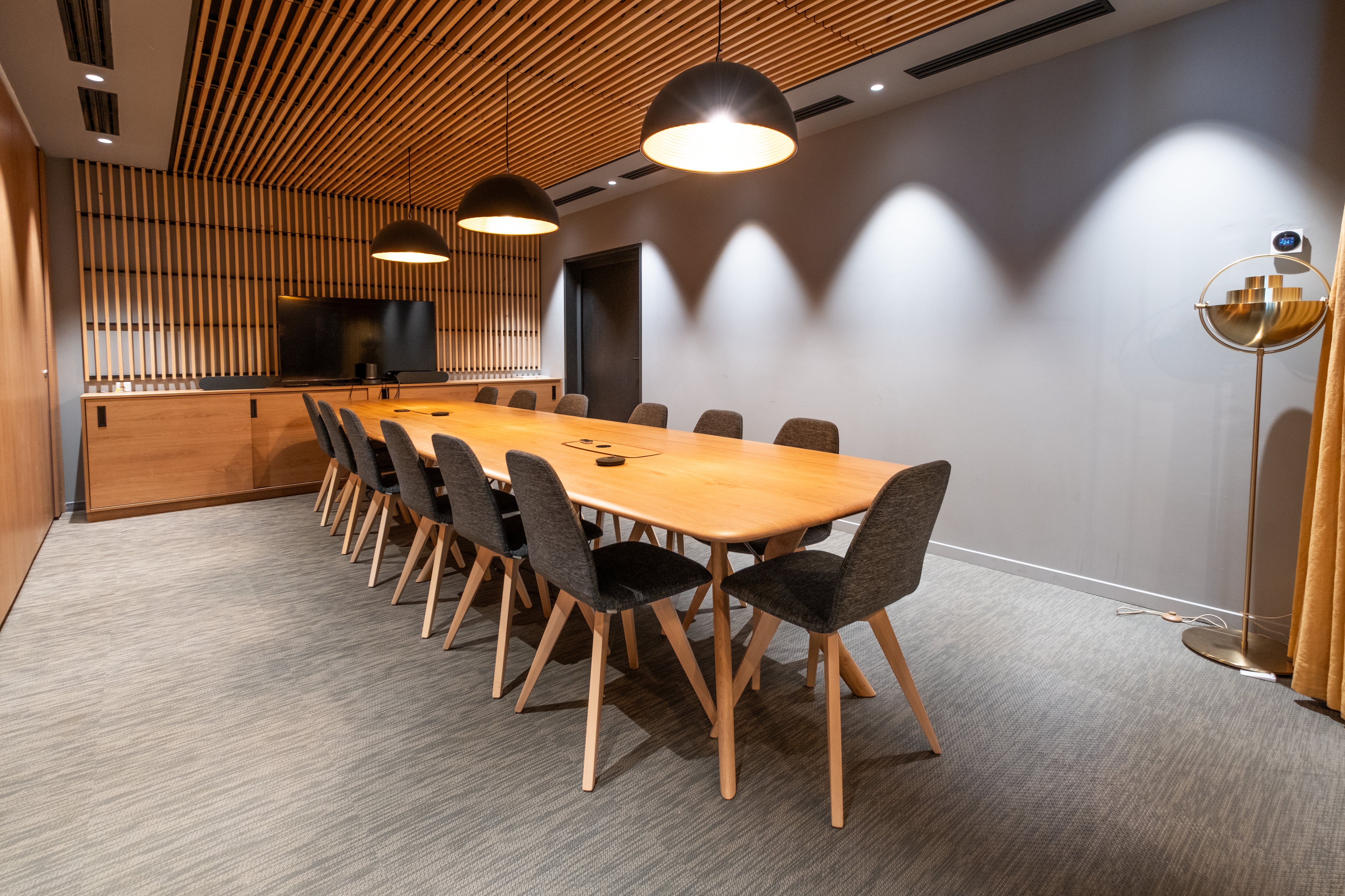 meeting romm wiht large wooden conference table and fabric chairs