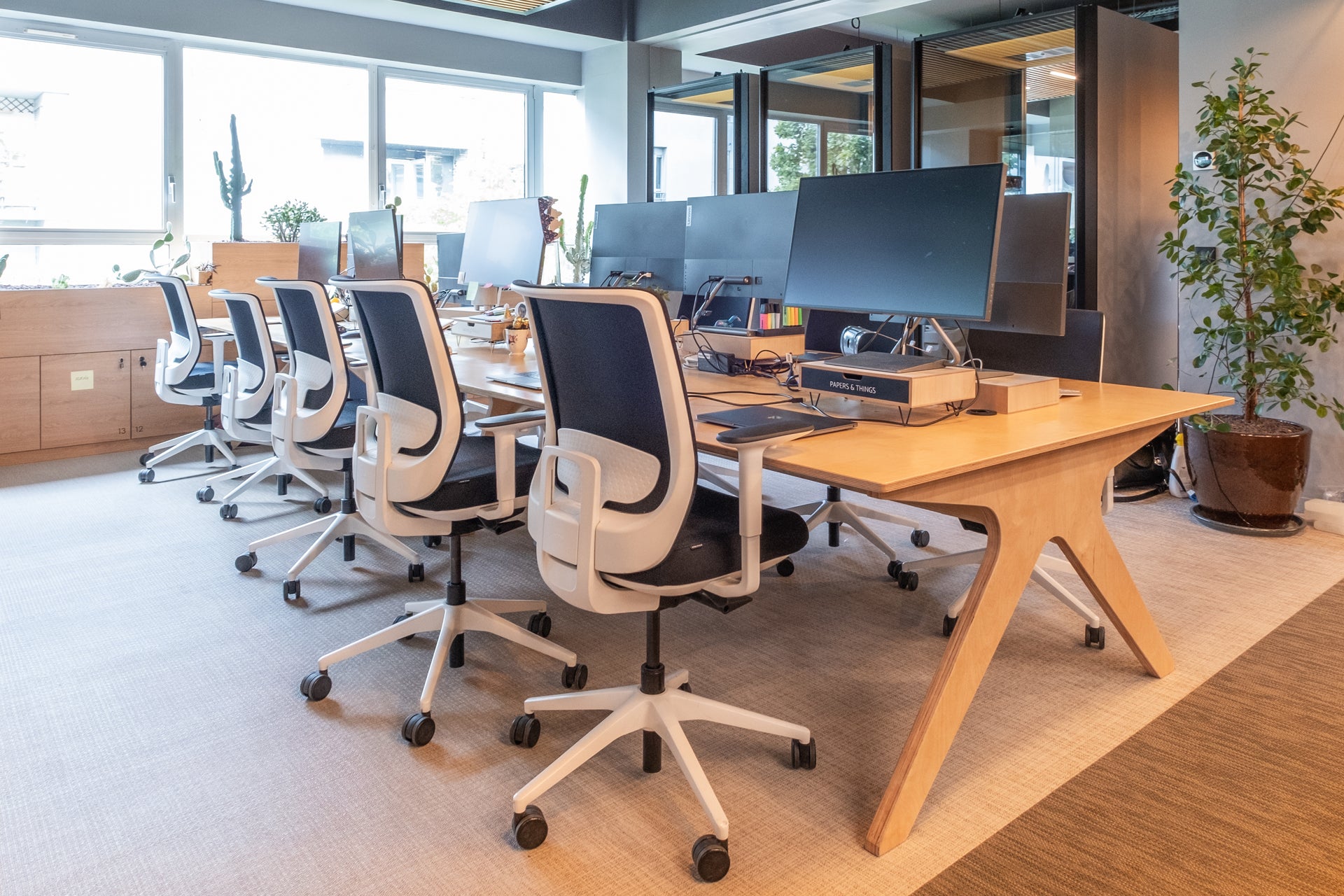 Modern office setup with desks, chairs, and computer monitors.