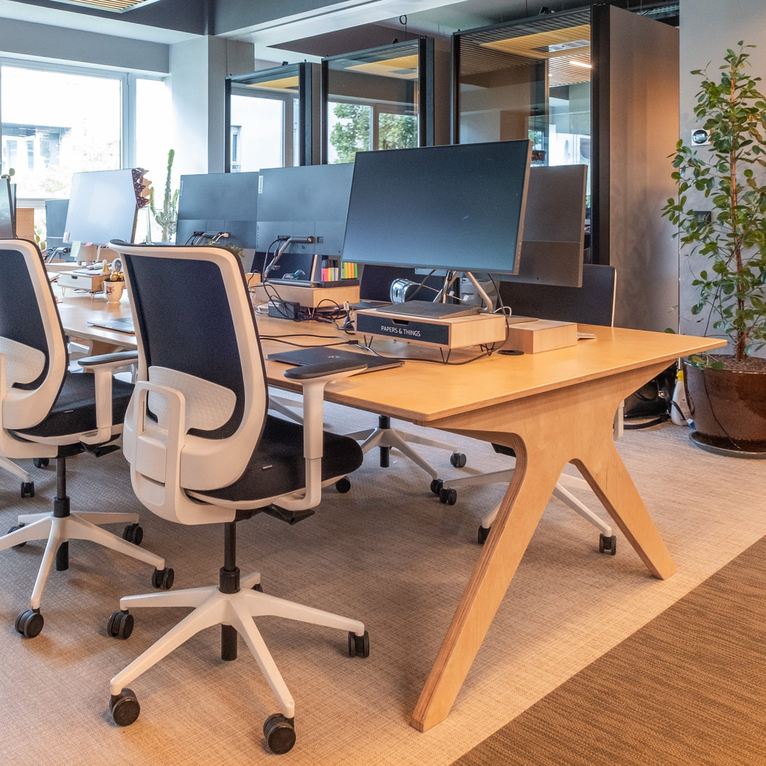 Modern office setup with desks, chairs, and computer monitors.
