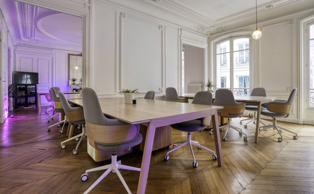 Modern office with wooden tables and chairs in a well-lit room.