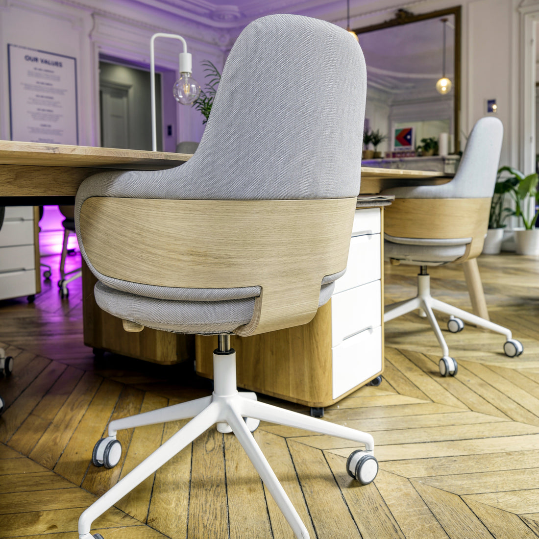 Gray comfortable ergonomic office chair and desk with wooden frame in a modern office setting