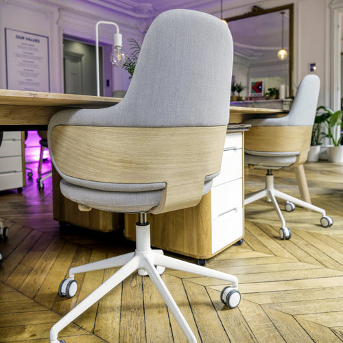 Gray comfortable ergonomic office chair and desk with wooden frame in a modern office setting