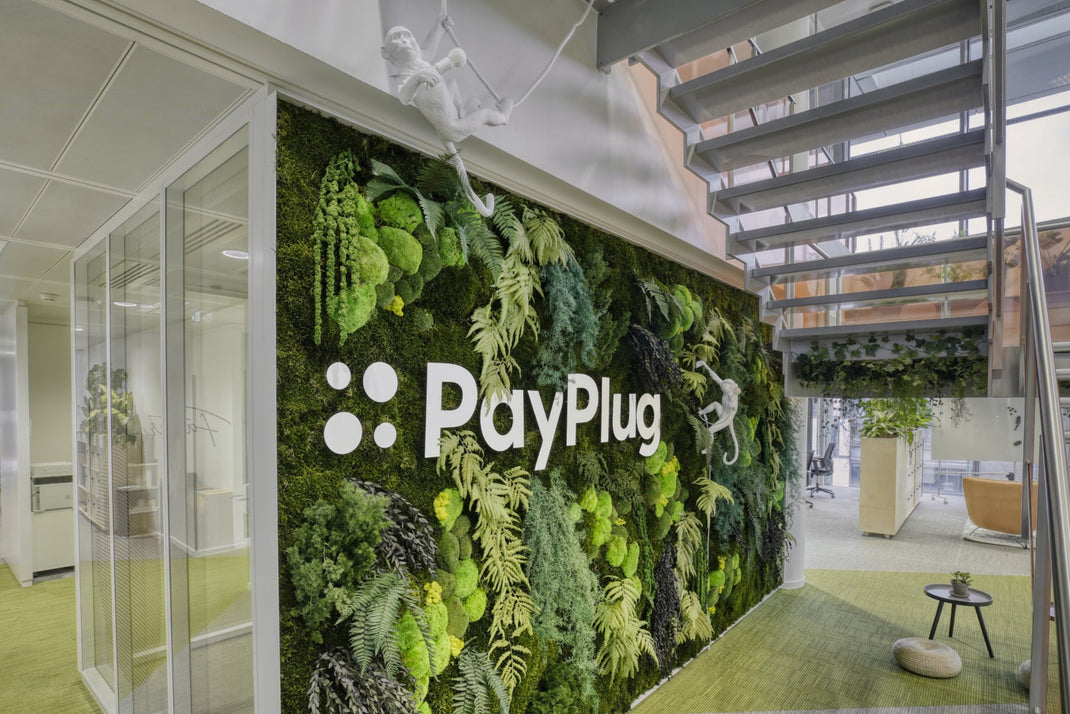 PayPlug logo on a green living wall in an office setting
