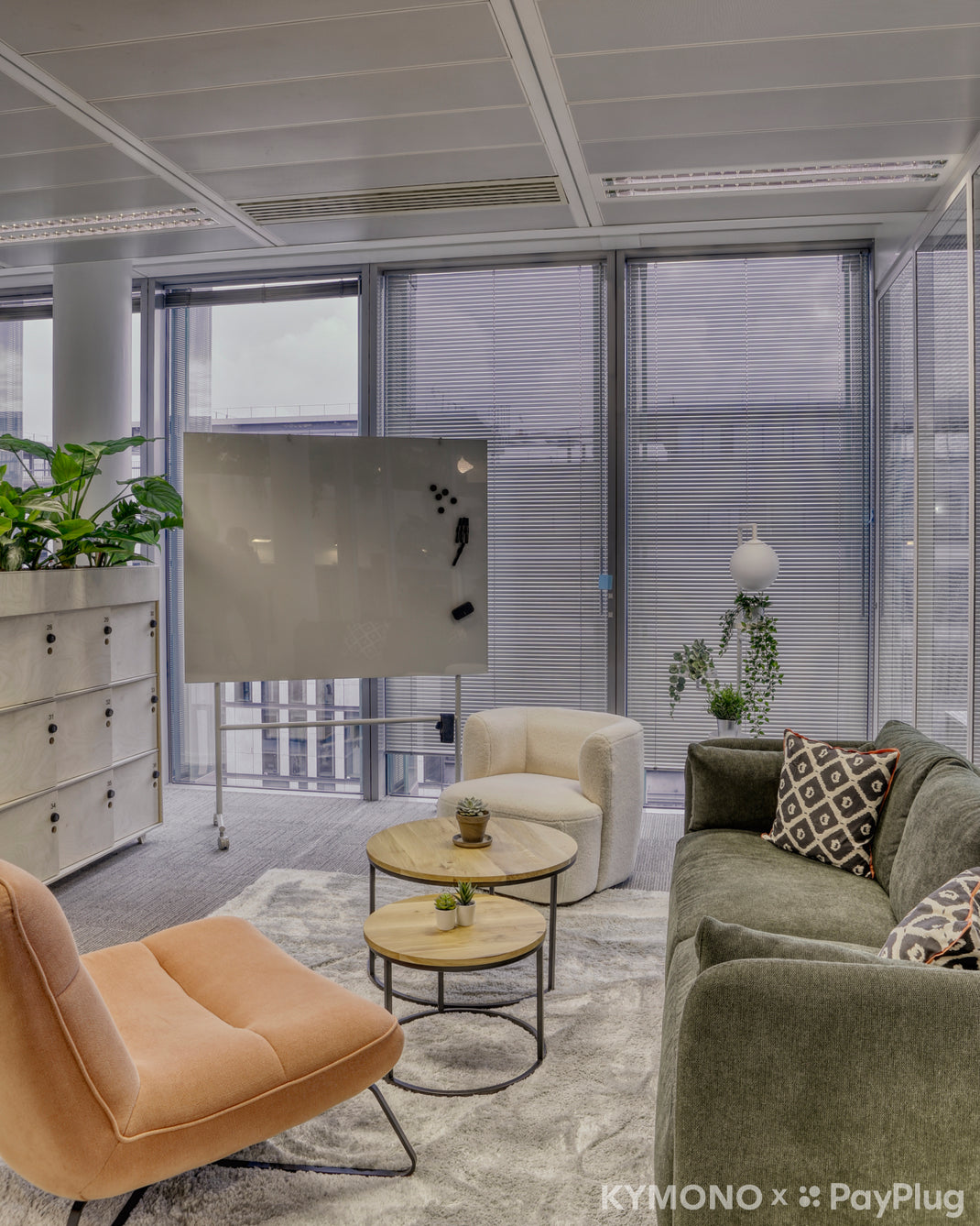 Modern office space with a couch, chairs, and a whiteboard.