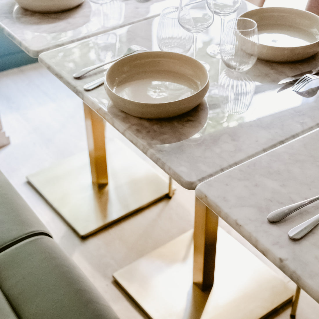 Dining table set with plates, glasses, and cutlery on marble surface