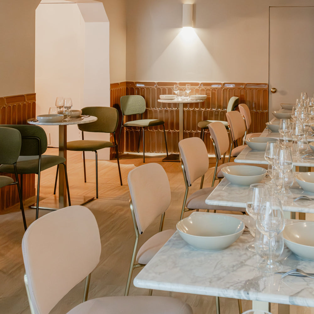 Modern restaurant interior with tables, chairs, and decorative elements.