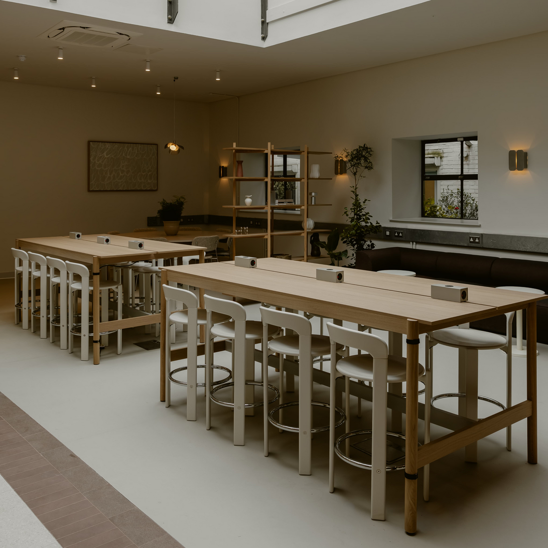 Modern interior with tables, chairs, and a high ceiling.