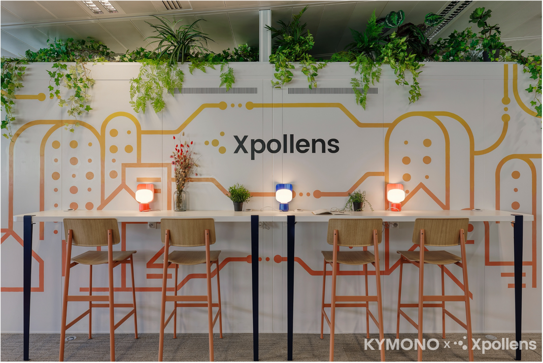 Modern office setup with 'Xpollens' branding on a decorative wall.