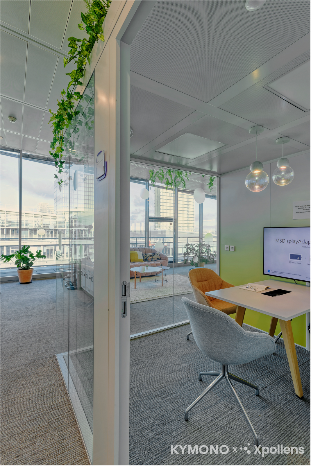 Modern office space with glass walls, furniture, and a view of the city.