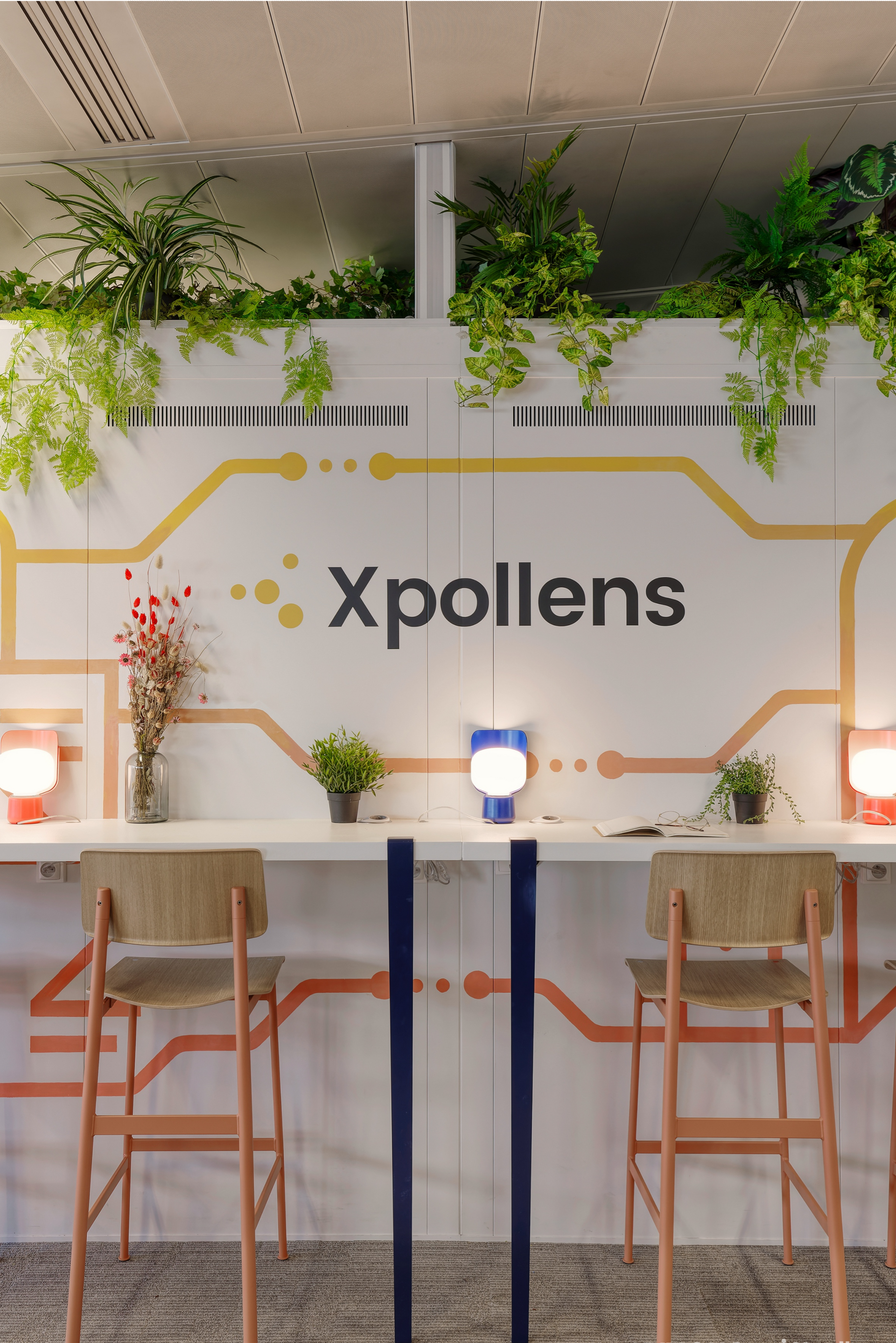 Modern office space with 'Xpollens' branding on a wall, featuring a table and chairs.
