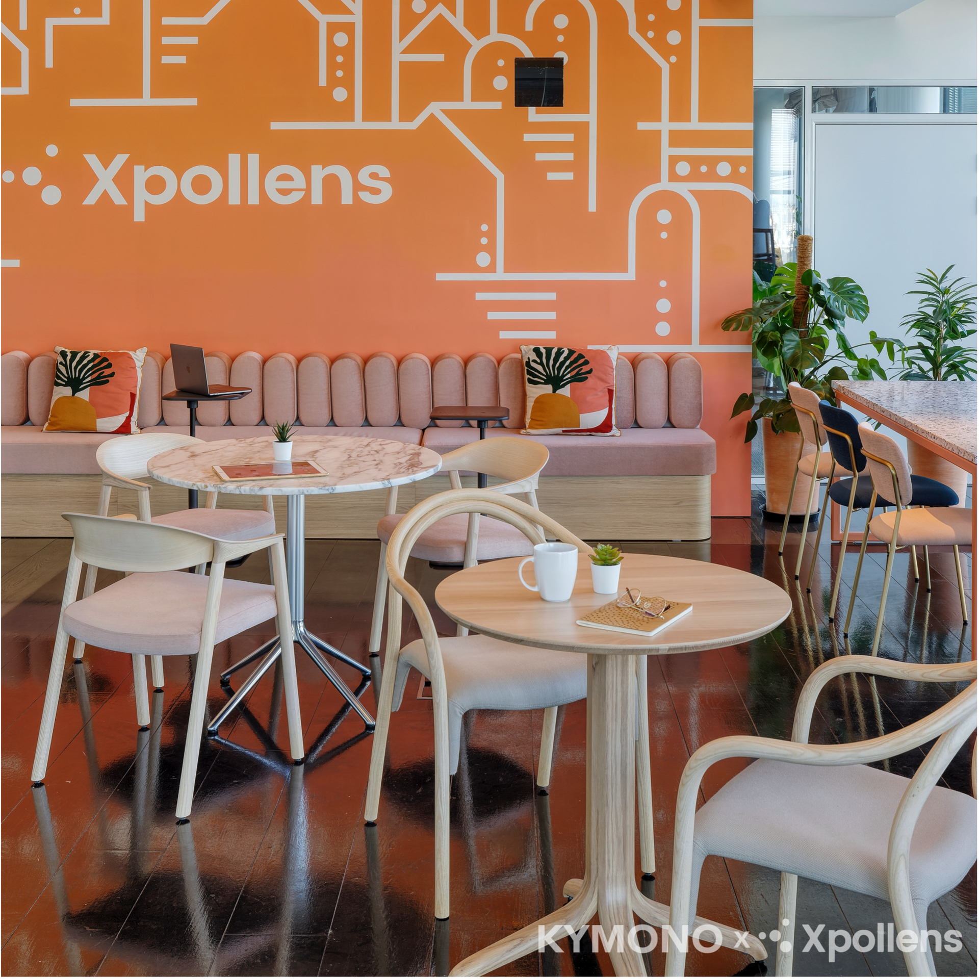Modern cafe interior in office with wooden tables, chairs, and a branded wall.