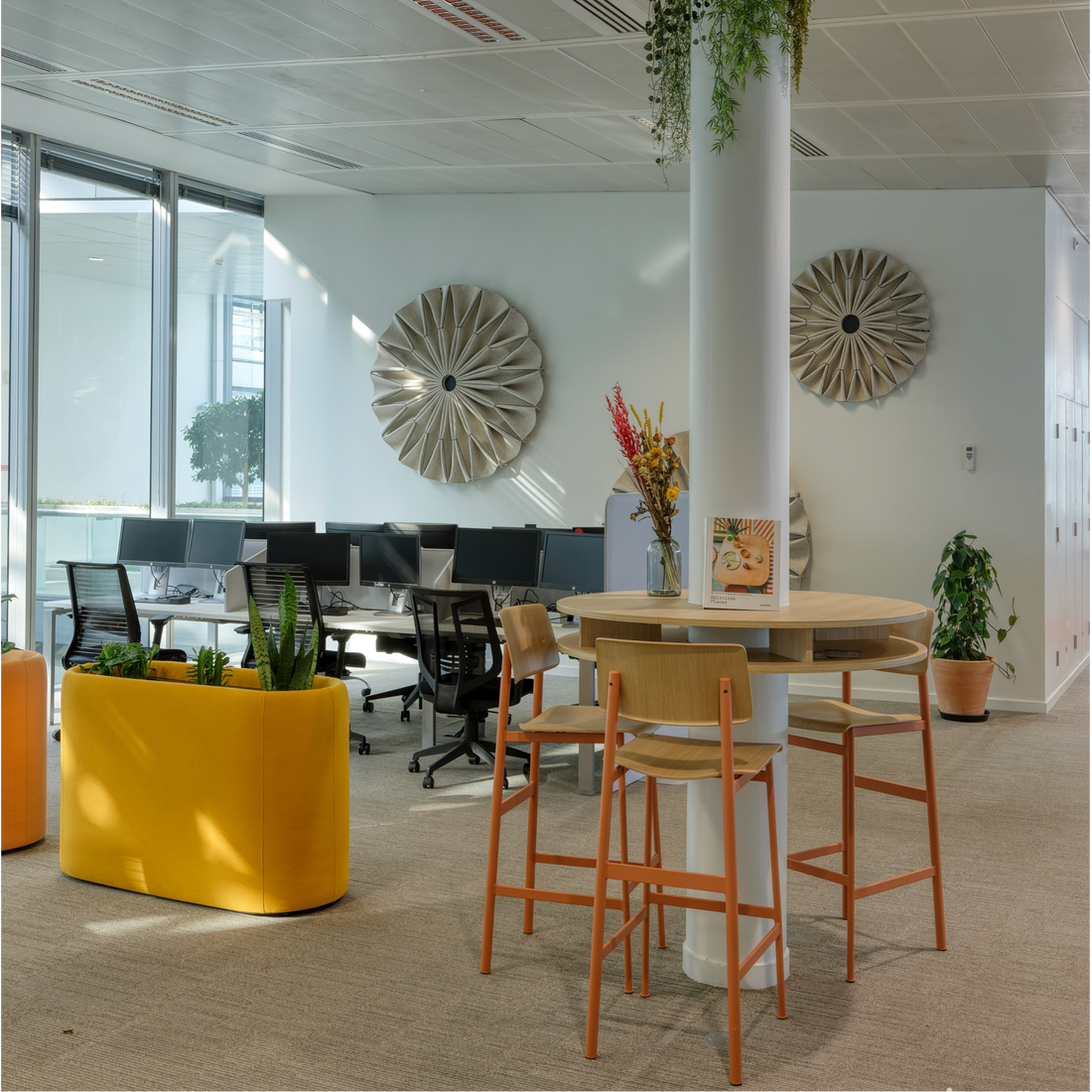 Modern office space with a high table, chairs, and decorative elements.